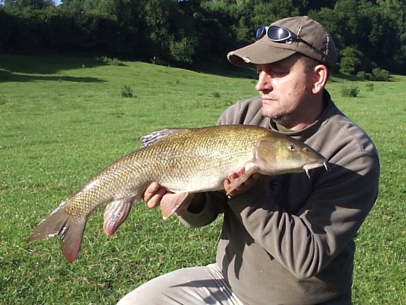 Fisherman filling pva mesh with trout pellets while carp fishing